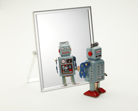 toy robot looking in the mirrorの写真素材
