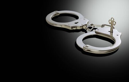 Closed police handcuffs close-up on a black background