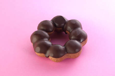 Sweet chocolate donut on pink background. Dessert foodの写真素材