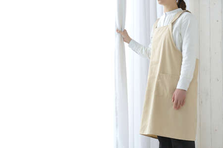 Woman opening curtains and ventilatingの写真素材