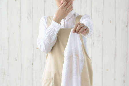 Housewife who is careful about the smell of indoor dried towelsの写真素材