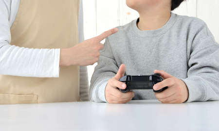 The mother's hand to pay attention to children who are only playing gamesの写真素材