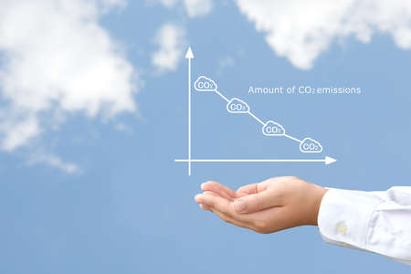 Children's hands holding up a graph of carbon dioxide reductionの写真素材