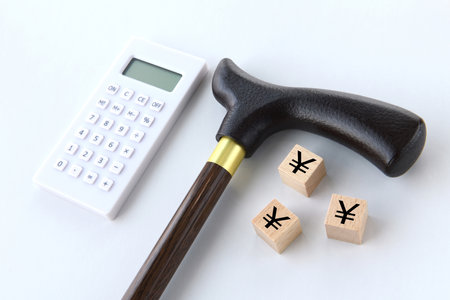 Nursing care, retirement expenses, and money image - Walking cane and circle letter blockの写真素材