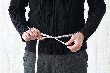 Man measuring waist circumference