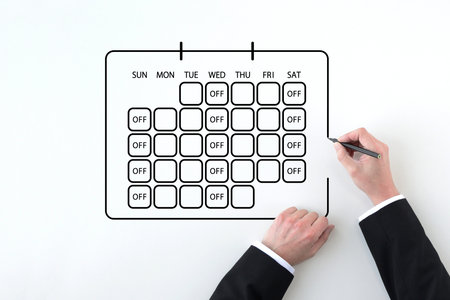 The hand of a man in a suit drawing a calendar reflecting the three-day work week systemの写真素材
