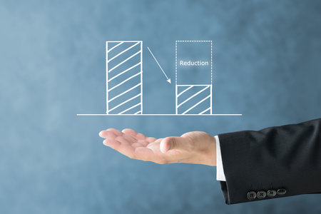 Graph and businessman's hand showing image of cost reduction and waste reductionの写真素材