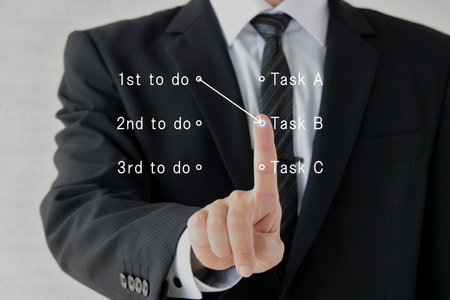 Image of a businessman deciding work prioritiesの写真素材
