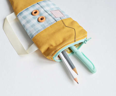 Handmade fabric zipper pouch and pencils over whiteの写真素材