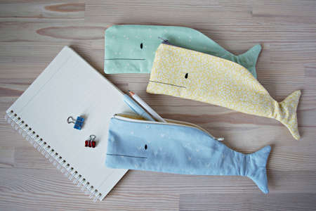 Whale pencil cases, notes and pens on the wooden tableの写真素材