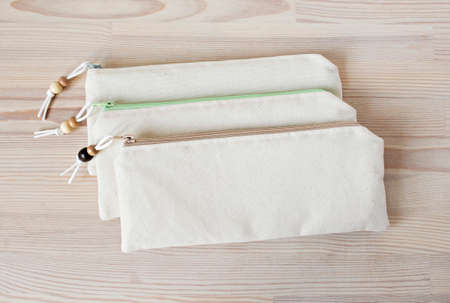 Handmade cotton pencil cases with beads on the wooden tableの写真素材