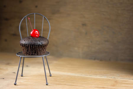Chocolate cupcakes on a chair, summer atmosphere, warm day, life style concept, copy space.