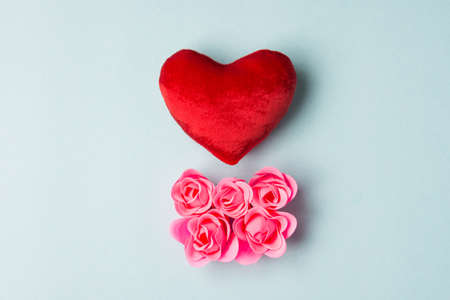 Red heart and pinkrose on blue background