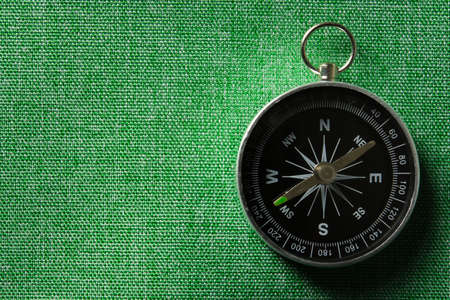 Close_up of magnetic compass on green backgroundの写真素材