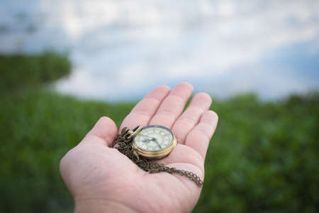Hand holding retro stopwatch in natural background.の写真素材
