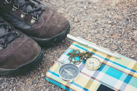 Old shoes pocket watch and compass. On the road, vintage style.