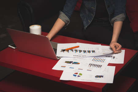 Financial report with chart and data on a laptop with business woman's hands at work