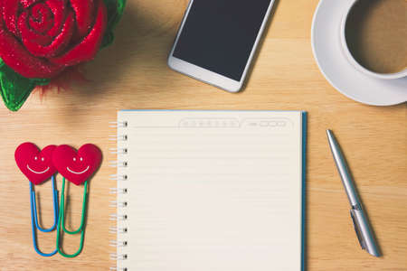 Simple workplace with a cup of coffee, notebook paper, pen, calculator, smartphone and glasses on...