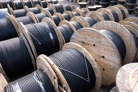 Wooden Coils Of Electric Cable Outdoor. High and low voltage cables in the storage.