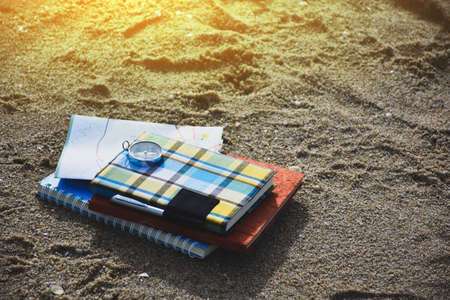 Notebooks, pens, watches, on the beach, travel ideas.