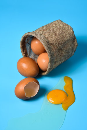 Fresh eggs in a sack bag on blue background.