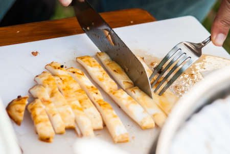 Cutiing squid in barbecue partyの写真素材