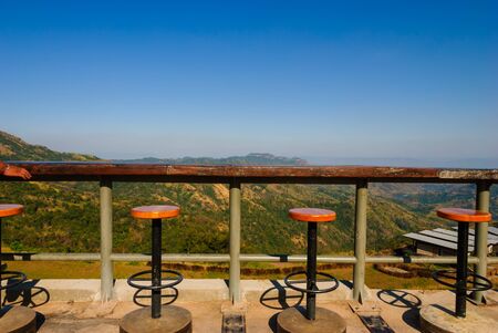 Wooden stools and table set with mountain view background at Phetchabun, Thailandの写真素材
