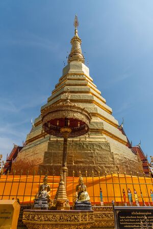 The golden pagoda with blue sky background. at Wat Prathat Cho Hae  temple, Prae province, Thailand.の写真素材