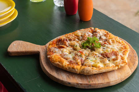 Fresh Homemade Pizza Hawaiian with cheese, pineapple and bacon on wooden tray.の写真素材