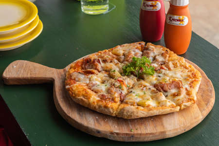 Fresh Homemade Pizza Hawaiian with cheese, pineapple and bacon on wooden tray.の写真素材