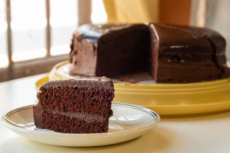 A slice of chocolate cake on a white plateの写真素材