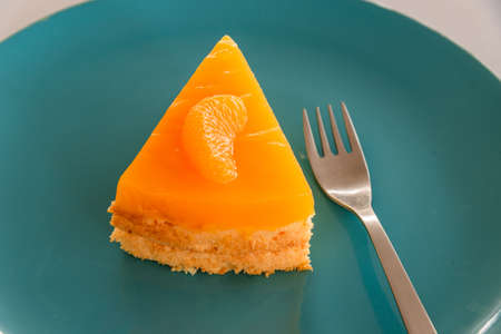 Piece of homemade orange cake with orange topping.の写真素材