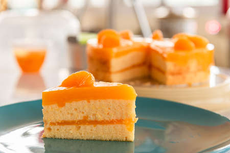Piece of homemade orange cake with orange topping.の写真素材