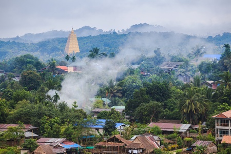 Golden pagoda and the morning mist at sangklaburi, thailandの写真素材