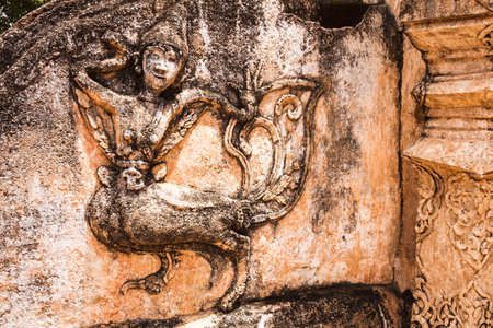 Ancient carving of kinnaree at the wall of lanna style temple in lampang, thailandの写真素材