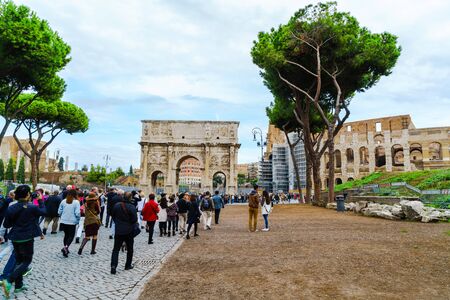 Rome, Italy - October 18, 2015 : Crowd of tourists walking to the Arch of Constantine and the Colosseum in Rome, Italy on October 18, 2015.のeditorial素材