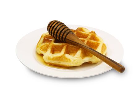 Waffle with honey in a plate on white backgroundの写真素材