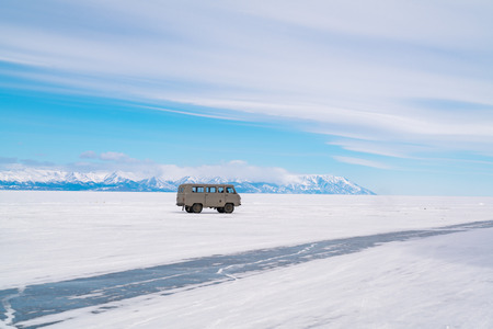 Grey car parks on snowy surface of Frozen Lake Baikal in Russia in winterの写真素材