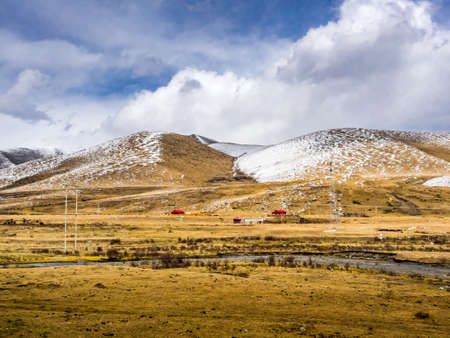 View of rural houses at the snow mountain in Sichuan, Chinaの写真素材