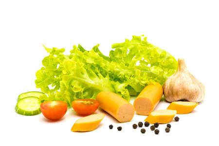 Sausages, garlic, lettuce, pieces of cucumber, black peppers and tomatoes on white backgroundの写真素材