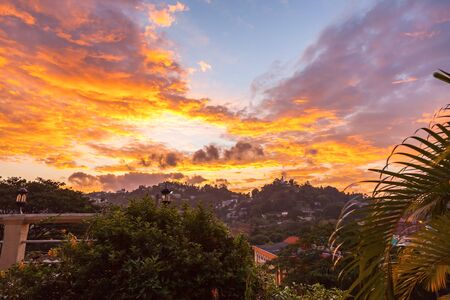 Aerial view of houses and the Bahiravokanda Vihara Buddha Statue on the mountain at sunset in Candy, Sri Lankaの写真素材