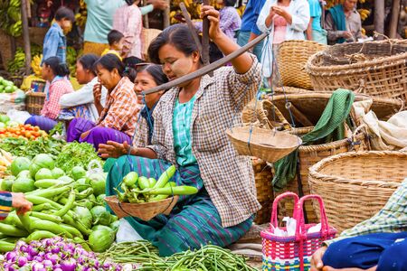 Bagan, Myanmar - Dec 9, 2010 : Burmese woman weighing vegetable at local street market in Bagan Myanmarのeditorial素材