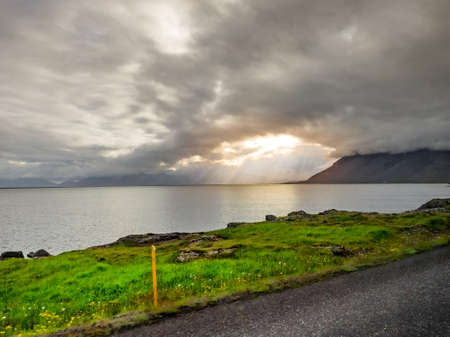 Beautiful view of sun rays at the sea and mountain in Icelandの写真素材