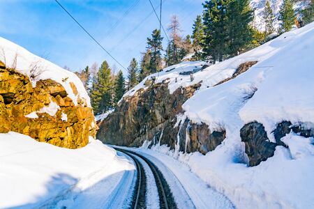 View of railway track and big rocks covered with snow in countryside, Switzerlandの写真素材