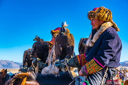 ULGII, MONGOLIA - OCTOBER 6, 2018 : Golden Eagle Festival. The Mongolian Horsemen on the horseback in traditional clothing with eagle in their hand ready for the competition at Ulgii in Mongoliaのeditorial素材