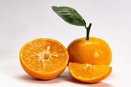 Side view of mandarin orange or Citrus reticulata a whole, a half and a piece with leaf on white backgroundの写真素材