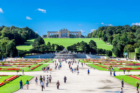 Vienna, Austria - August 9, 2011 : View of beautiful Schonbrunn Palace garden with Gloriette and Neptune Fountain in the background and tourists walking around in Vienna, Austria.のeditorial素材