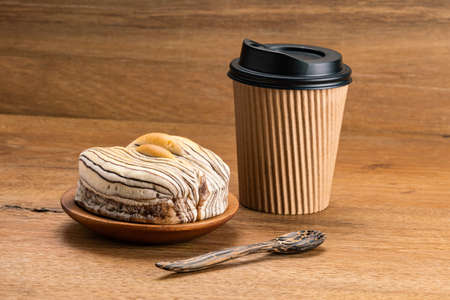 View of delicious breakfast Chocolate Flavored Bread on wooden plate with paper cup of coffee and...