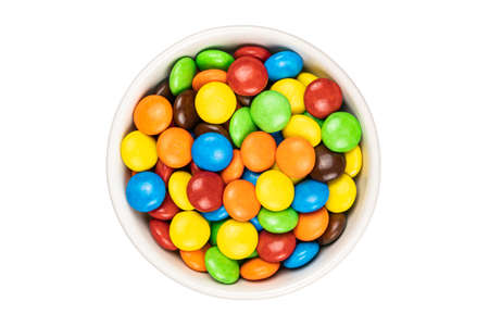 Top voew of multicolored chocolate button shape candy in white ceramic cup on white background with clipping path.の写真素材