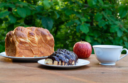 Breakfast at a green teak forest background. Breakfast with a loaf of homemade bread in white...